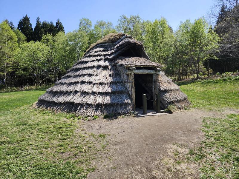 Almost fully reconstructed pit dwelling.