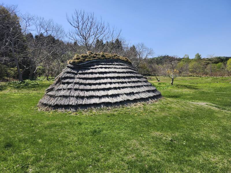 Almost fully reconstructed pit dwelling.