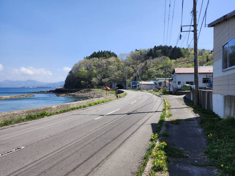 The coast road disappears into a tunnel.