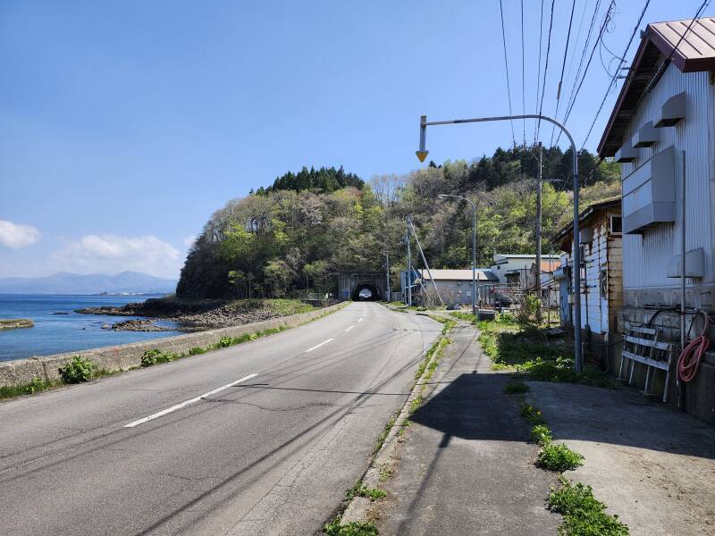 The coast road disappears into a tunnel.