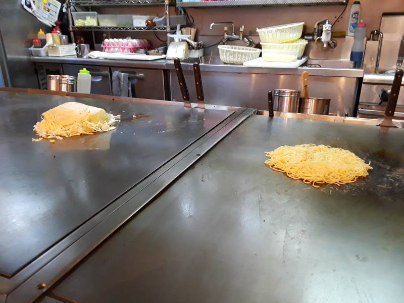 Okonomiyaki cooking in Hiroshima, batter base and noodle base.