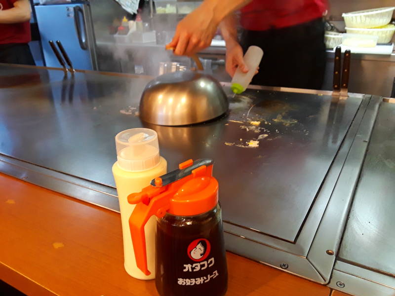 Okonomiyaki chef in Hiroshima, steaming the stack.
