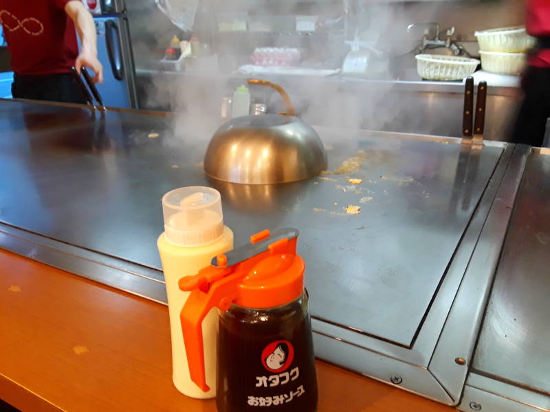 Okonomiyaki chef in Hiroshima, steaming the stack.