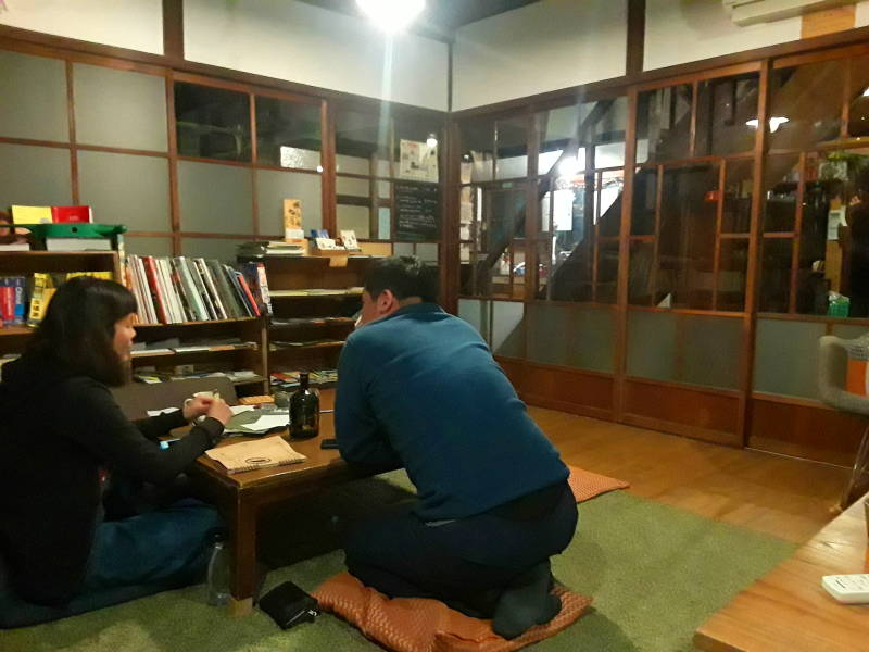 Travelers talk in the evening in the shared room at the ryokan.