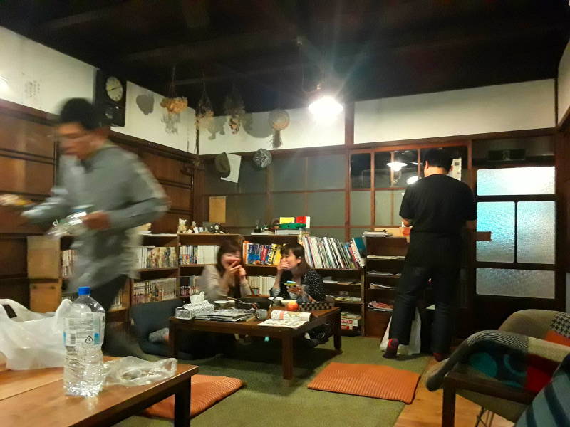 Travelers talk in the evening in the shared room at the ryokan.