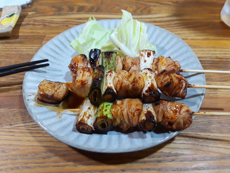 Yakitori in a small izakaya in Ise, Japan. Grilled chicken thigh and onion with cabbage leaf.