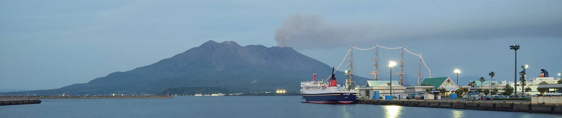 Ash plume rising from Sakurajima in the early evening, seen from Kagoshima's harbor.