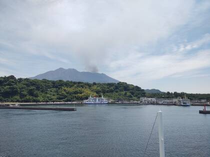 Sakurajima volcano with an ash plume at dusk, seen form Kagoshima harbor.
