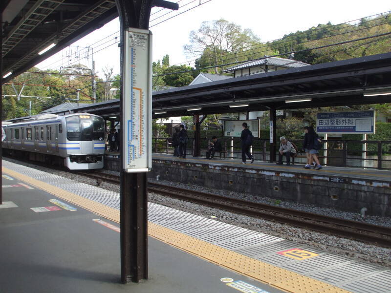 Unwrapping and eating o-nigiri, rice ball with fish, at Kita-Kamakura train station in Japan.