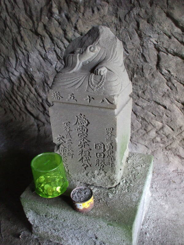 Memorial in a yagura or samurai tomb along path around Kamakura.