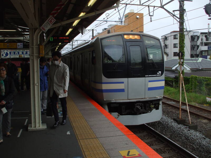 Train arrives in train station in Kamakura, Japan.
