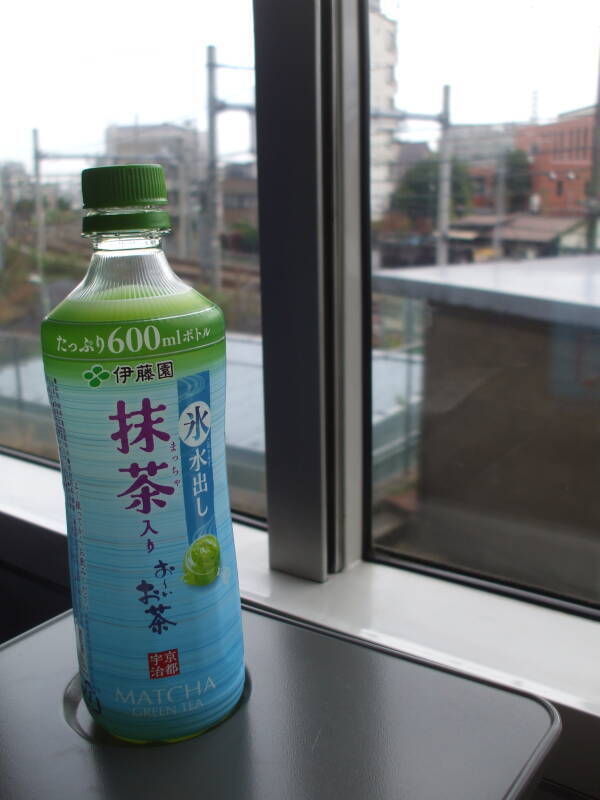 Drinking green tea with o-nigiri, rice ball with fish, on board a train in Japan.