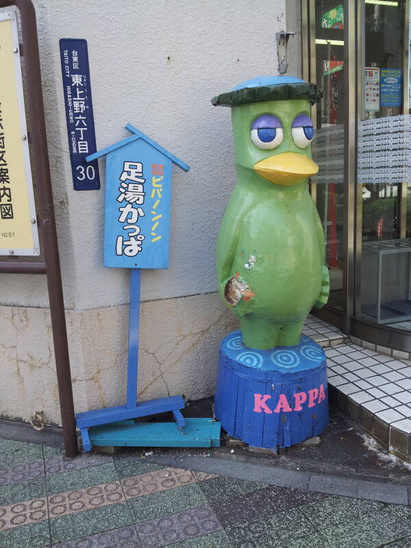 A street sign and kappa statue in Tōkyō.