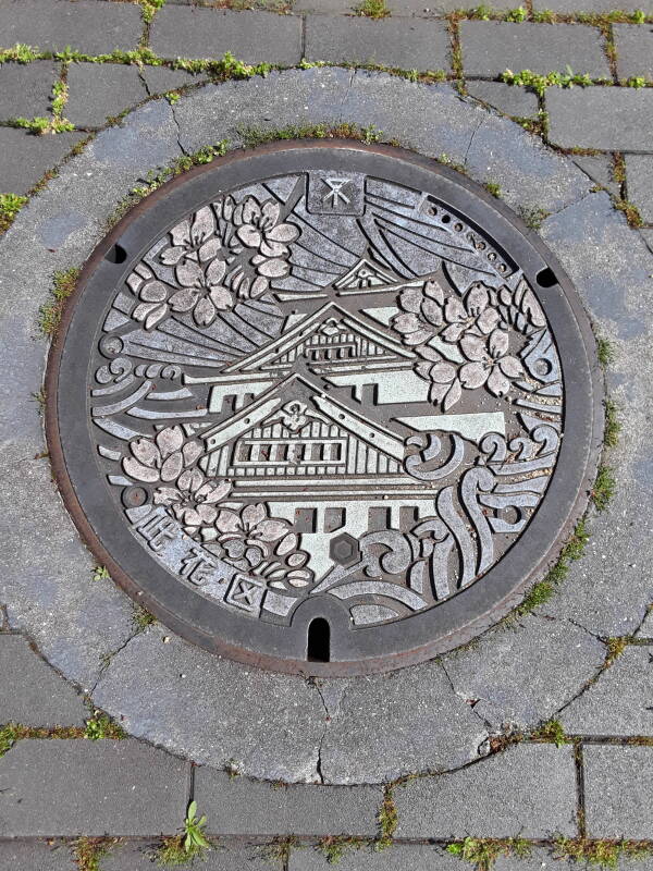 Custom manhole cover in Osaka showing the castle.