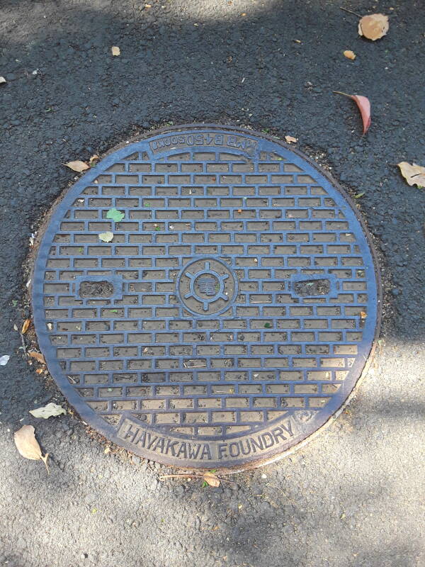 Custom manhole cover in Ueno park in Tōkyō, reading 'HAYAKAWA FOUNDRY' and 'MB B450 500Kg.