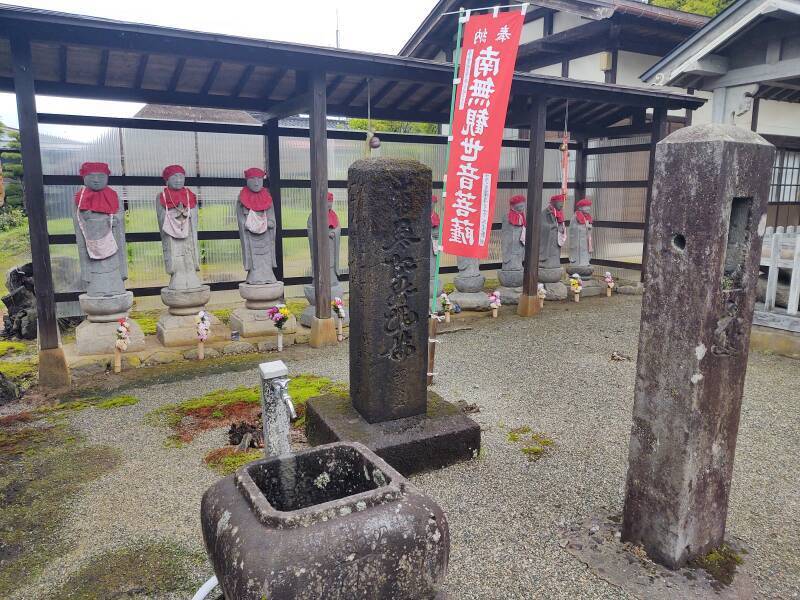 Stone statues of Jizō wearing red caps and bibs.