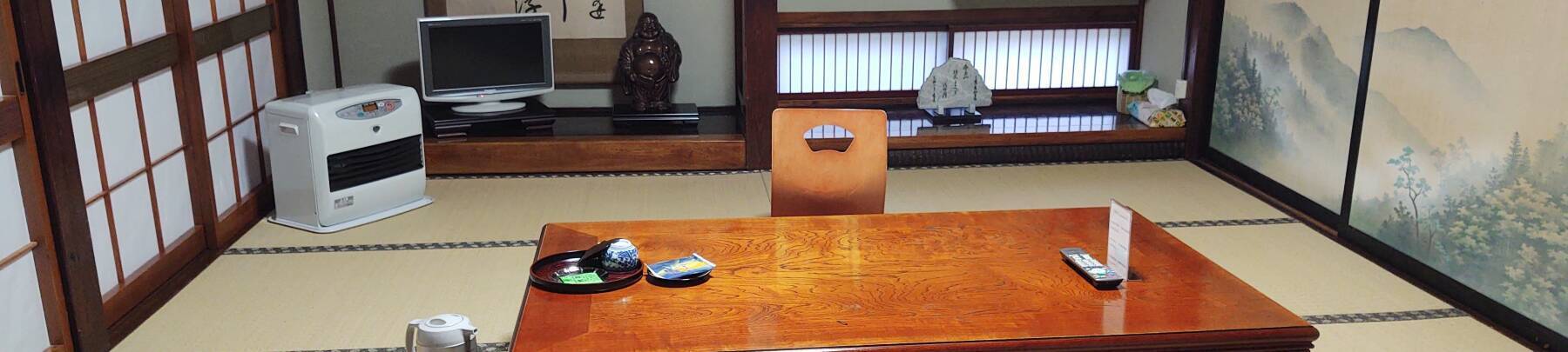 Tatami mat room with paper sliding doors, low table, and heater.