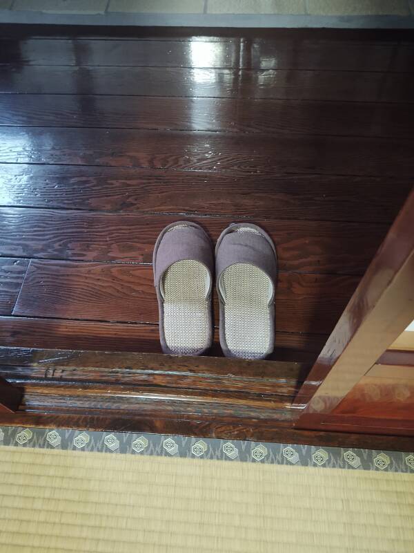 Wooden floor in hallway, tatami mats in the room.