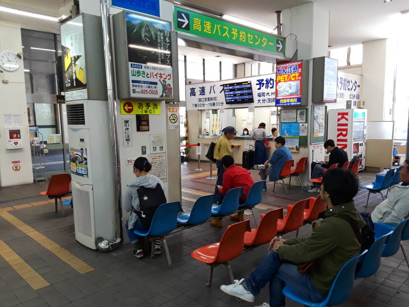 People waiting at the bus station across from the train station in Nagasaki.
