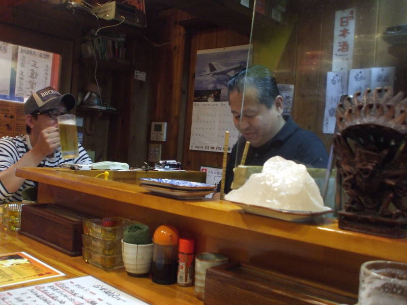 Inside a small izakaya in Dōtonbori at night in Osaka.