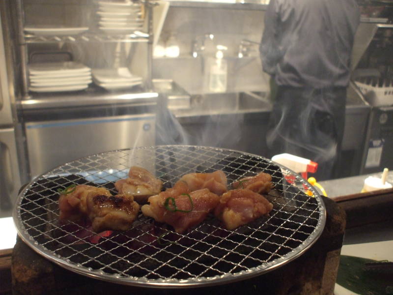 Personal charcoal grill in an izakaya in Dōtonbori at night in Osaka.