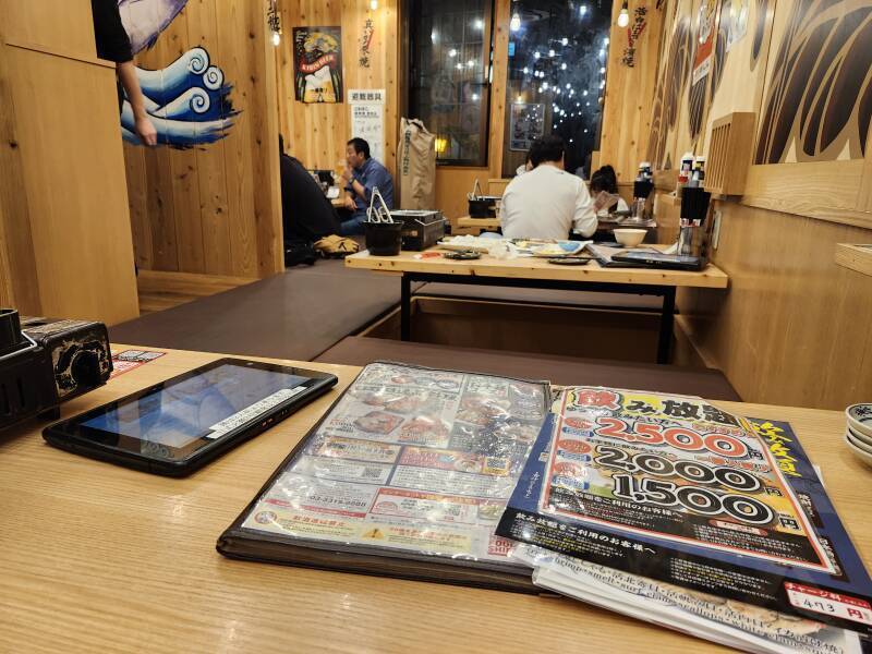 Menu and tables at a seafood restaurant in Otaru.