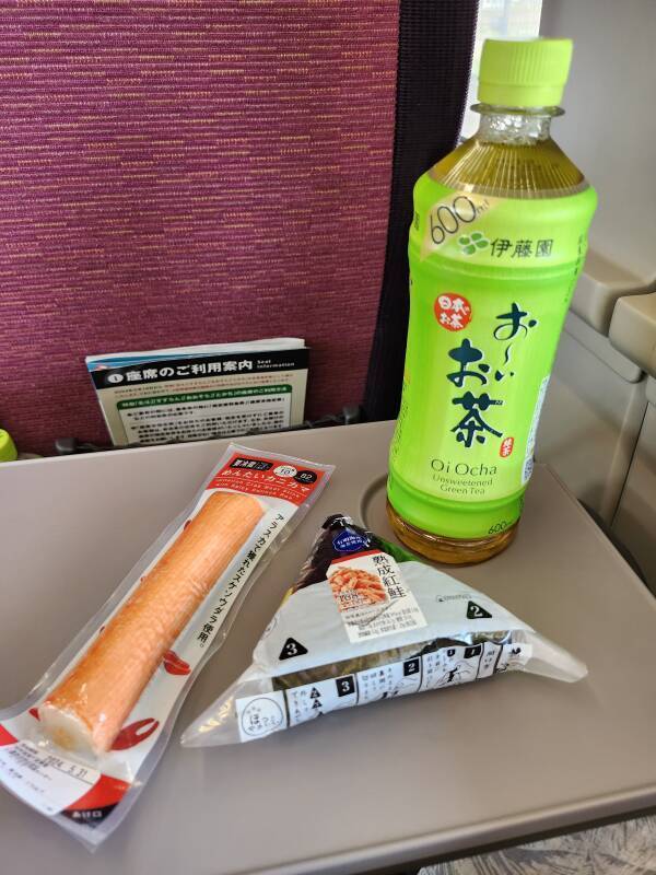 Breakfast on board: imitation crab leg stick and a salmon rice ball, with green tea.