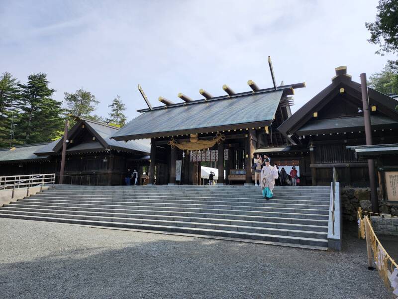 Shintō priest descending steps from the main gate into the Hokkaidō Shrine.