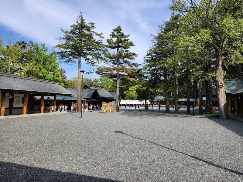 Multiple buildings around a gravel courtyard at Hokkaidō Shrine.