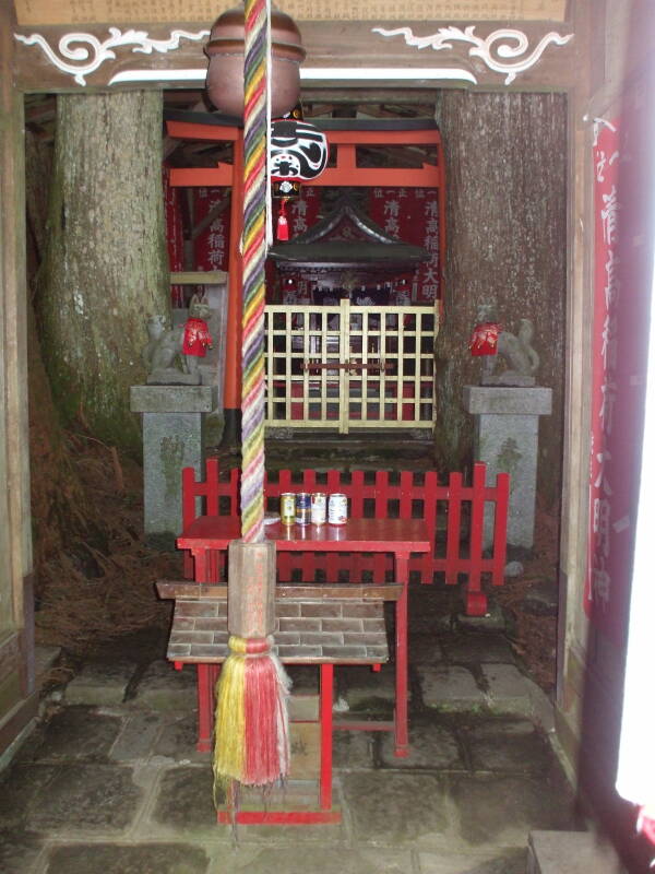 Rope, bell, fox guardians within Kiyotaka Inari shrine in Kōyasan.