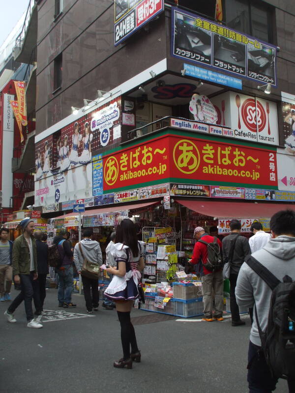 Girl wearing a maid costume in Akihabara handing out fliers for a maid café.