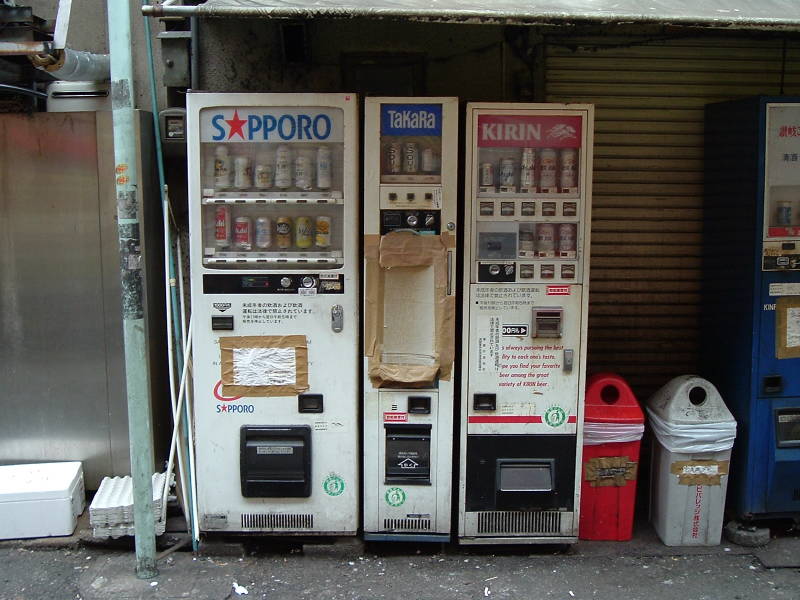 Vending machines selling beer in Ameya-Yokochō market under the Yamanote Line tracks near Ueno Station.