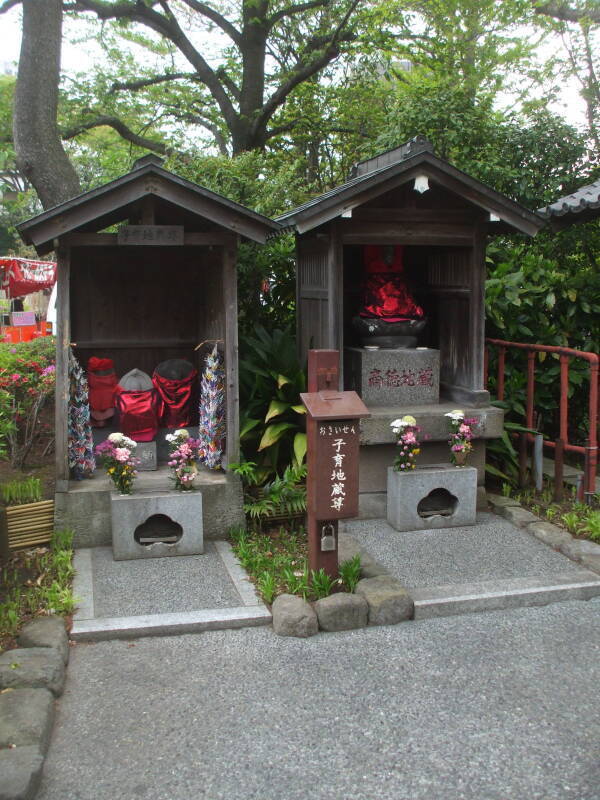 Jizō statues with red caps and bibs at Mitsumine Shrine, a shrine complex next to the Sensō-ji Buddhist temple in Asakusa, Tōkyō.