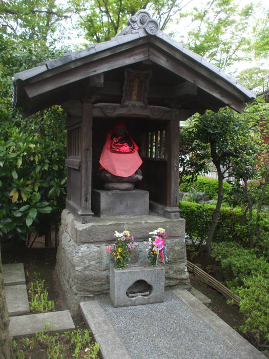 Jizō statues with red caps and bibs at Mitsumine Shrine, a shrine complex next to the Sensō-ji Buddhist temple in Asakusa, Tōkyō.