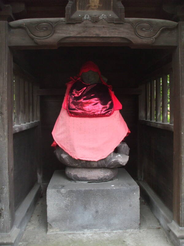 Jizō statues with red caps and bibs at Mitsumine Shrine, a shrine complex next to the Sensō-ji Buddhist temple in Asakusa, Tōkyō.