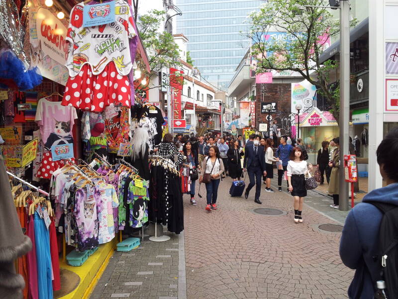 Crowds of people pass clothing shops on Takeshita-dori or Takeshita Street in Harajuku.