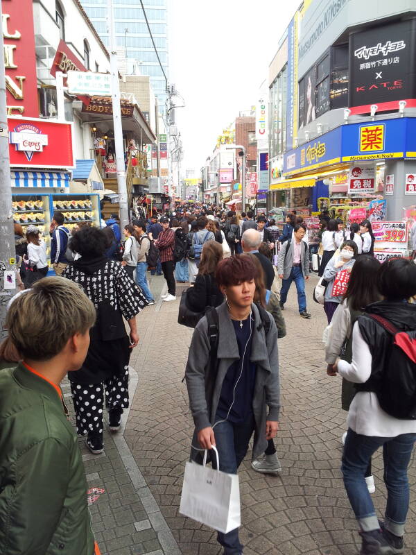 People pass crowded colorful shops on Takeshita-dori or Takeshita Street in Harajuku.