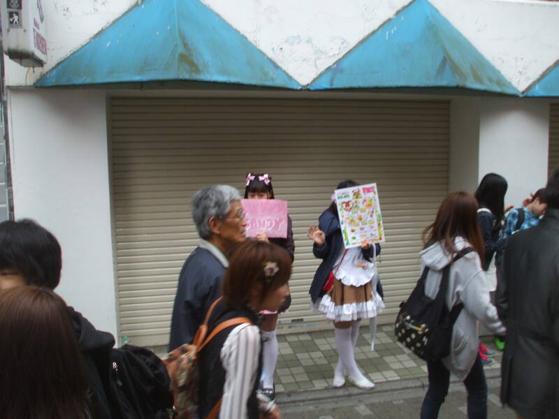 Girls in maid costumes promoting shops on Takeshita-dori or Takeshita Street in Harajuku.