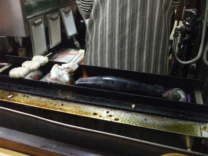 Various seafood and vegetables on the grill at a small izakaya in Omoide Yokochō, Shinjuku, Tōkyō