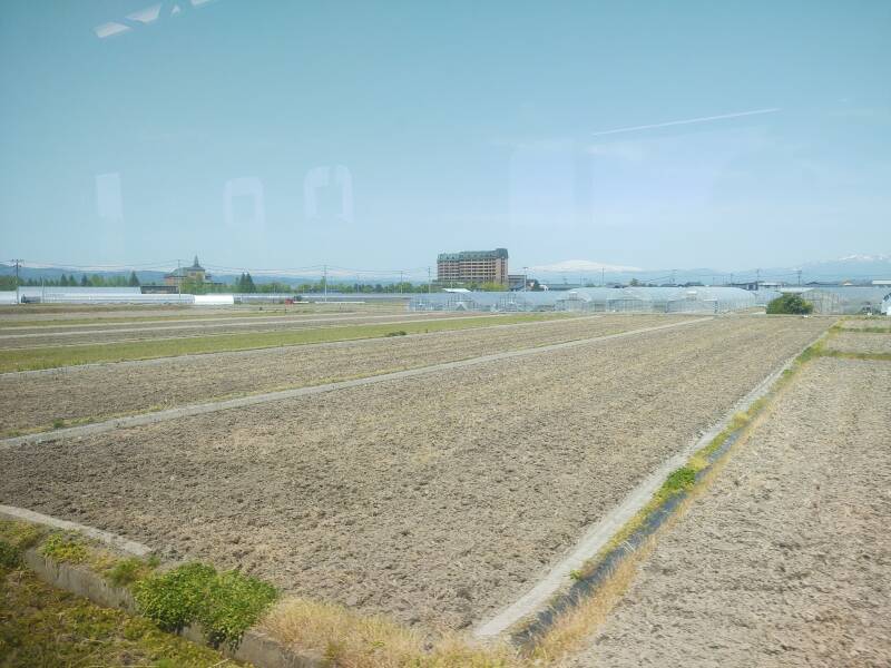 View of farmland and mountains to the northwest from a train en route from Yamagata to the Yamadera temple complex.