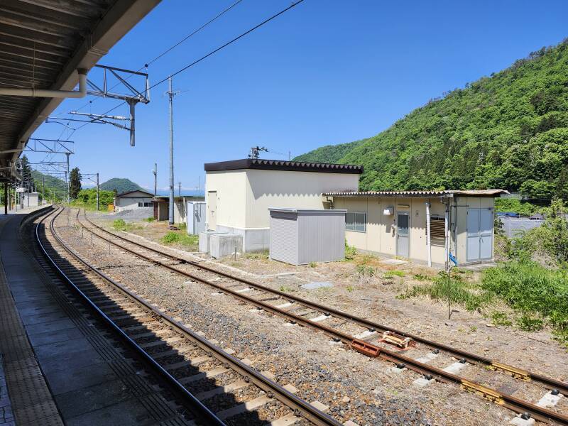 Narrow-gauge rail lines with snow covered mountains in the distance.