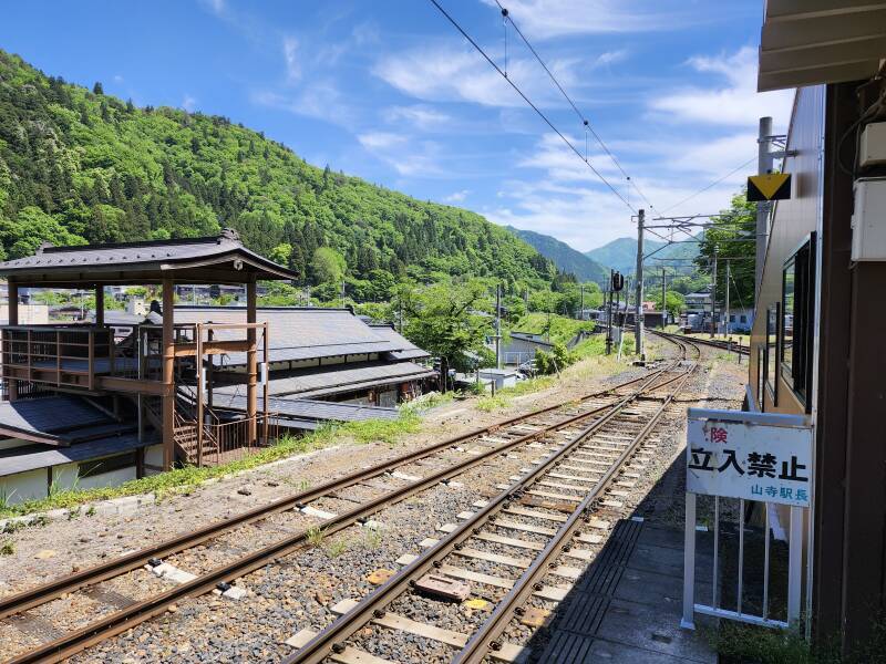 Narrow-gauge rail line into tree-covered mountains.