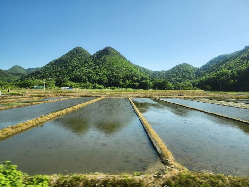 View of rice paddies and mountains to the south of the line as we enter the mountains on a train en route from Yamagata to the Yamadera temple complex.