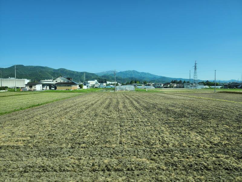 View of farmland and mountains to the southeast from a train en route from Yamagata to the Yamadera temple complex.