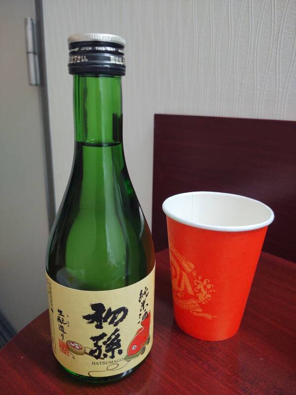 Bottle of 7/11 sake and a cup in Yamagata.