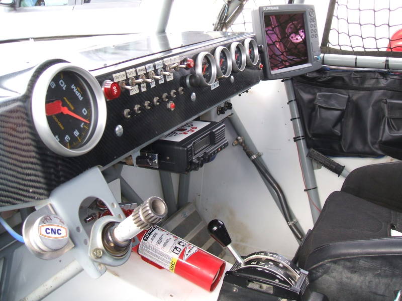 Interior of Baja 1000 off-road race truck: dashboard and instrument panel, steering column, fire extinguisher, GPS, radio.