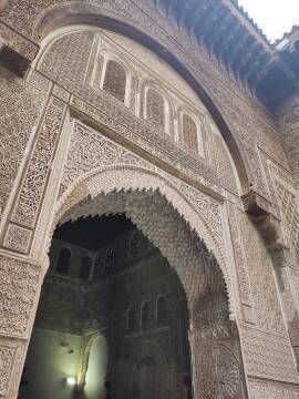 Elaborately decorated arched doorway at al-Attarine Madrasa in Fez.