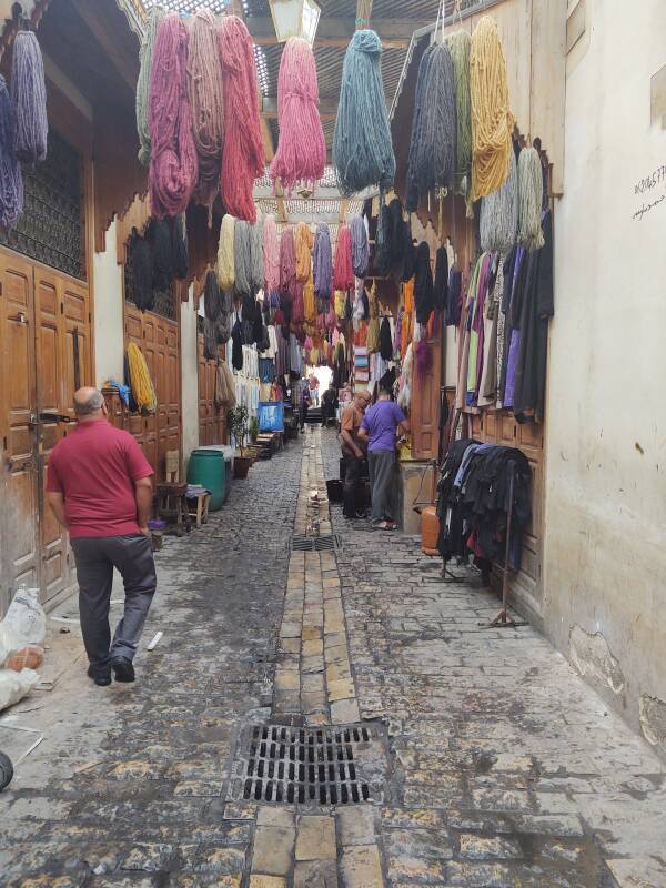 Yarn and fabrics hanging to dry after being dyed in Fez el Bali medina along Tala'a Sghira.