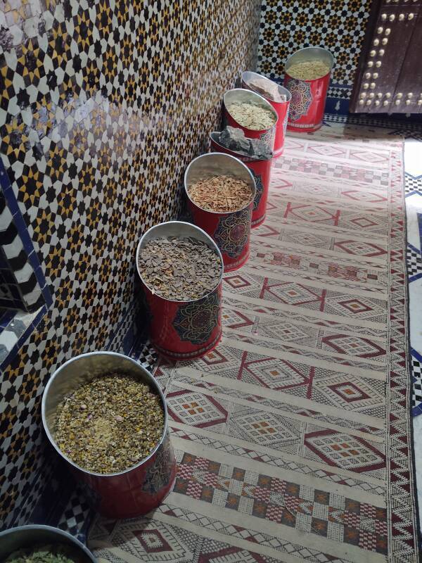 Cans of spices in the entryway of a spice shop in Fez el Bali medina along Tala'a Sghira.