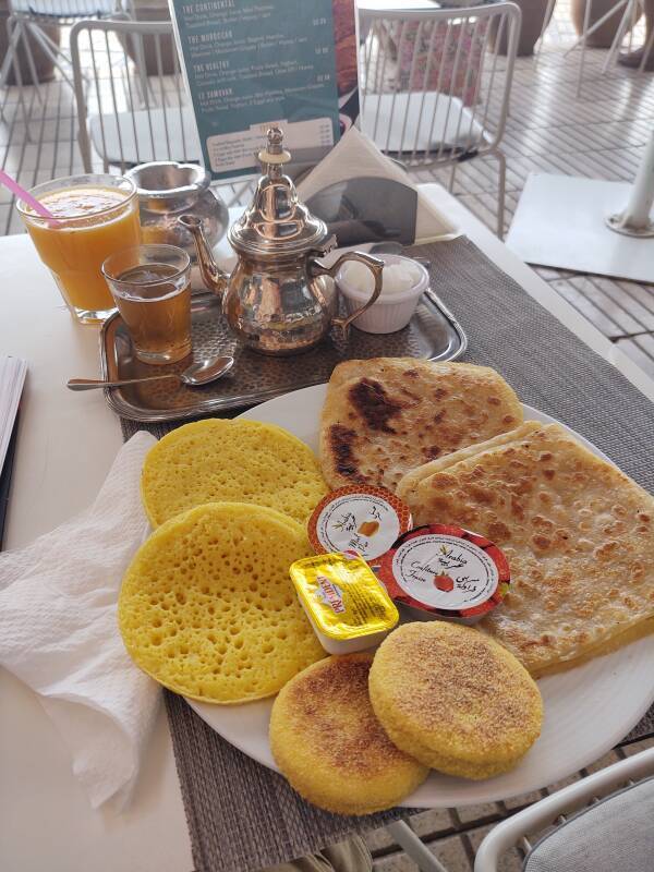 Breakfast in Marrakech: several varieties of bread, honey, jelly, orange juice, and tea.